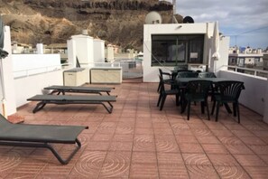 A rooftop terrace with lounge chairs, a table, and chairs. - Studio Playa Mogan Hungarian (Lomo Quiebre)