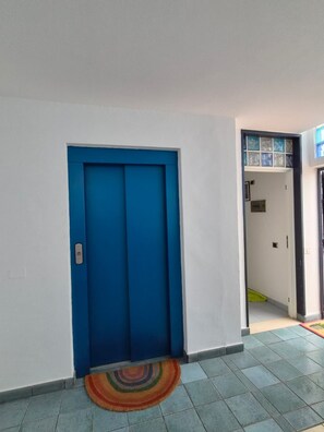 A hallway with a blue door, a colorful rug, and a tiled floor. - Studio Playa Mogan Center (Lomo Quiebre)
