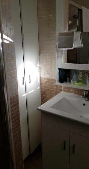 A bathroom with a white sink, a mirror, and a cabinet with toiletries. - Studio Playa Mogan Hungarian (Lomo Quiebre)