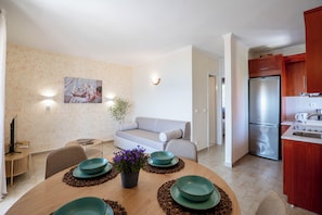 Een moderne keuken met een koelkast, houten kasten en een eethoek met een tafel gedekt voor vier personen.