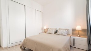 Ein Schlafzimmer mit einem Bett, Nachttischen und einem Kleiderschrank.