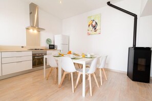 A modern kitchen with white cabinetry, a gas stove, and a black range hood.