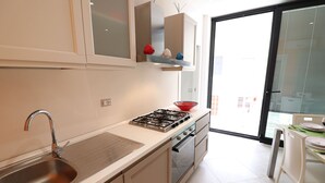 Een moderne keuken met een roestvrijstalen spoelbak, een gasfornuis en een inbouwoven.