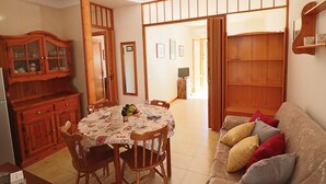 A dining area with a round table, chairs, and a cabinet. - Nice House Cecilia in Otranto (Otranto)