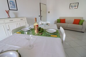A dining table set with plates, glasses, a bottle, and a corkscrew.