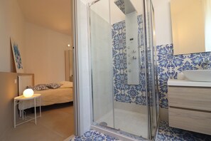 Een bad/douchecombinatie, een haardroger, handdoeken