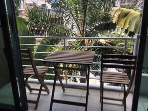 Enjoy a peaceful moment on this balcony overlooking a serene garden.
