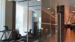 A modern gym with exercise equipment, large windows, and a staircase. - 3008 - Luxurious Ocean View 1BR Apartment in Muang Pattaya, Thailand (Muang Pattaya)