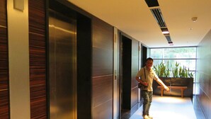 A modern hallway with wooden paneling, a bench, and a large window with plants. - 3237 - Luxurious City View Studio Condo in Muang Pattaya with Pool Access (Muang Pattaya)