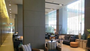 A modern lobby with a long corridor, seating area with sofas and chairs, and large windows providing natural light. - 3237 - Luxurious City View Studio Condo in Muang Pattaya with Pool Access (Muang Pattaya)
