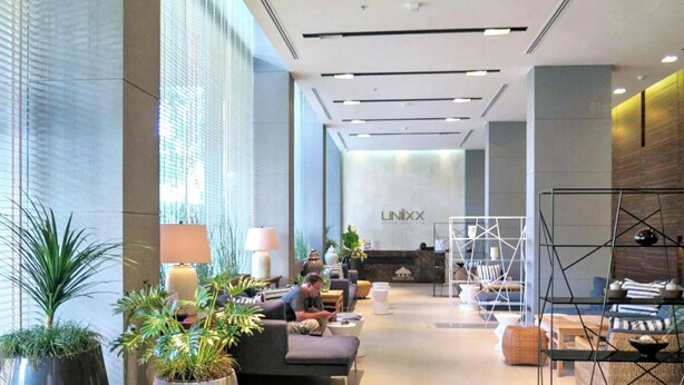 A modern hotel lobby with seating areas, a reception desk, and large windows. - 3237 - Luxurious City View Studio Condo in Muang Pattaya with Pool Access (Muang Pattaya)
