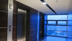 Un ascenseur offrant une vue sur la ville grâce à une grande fenêtre.