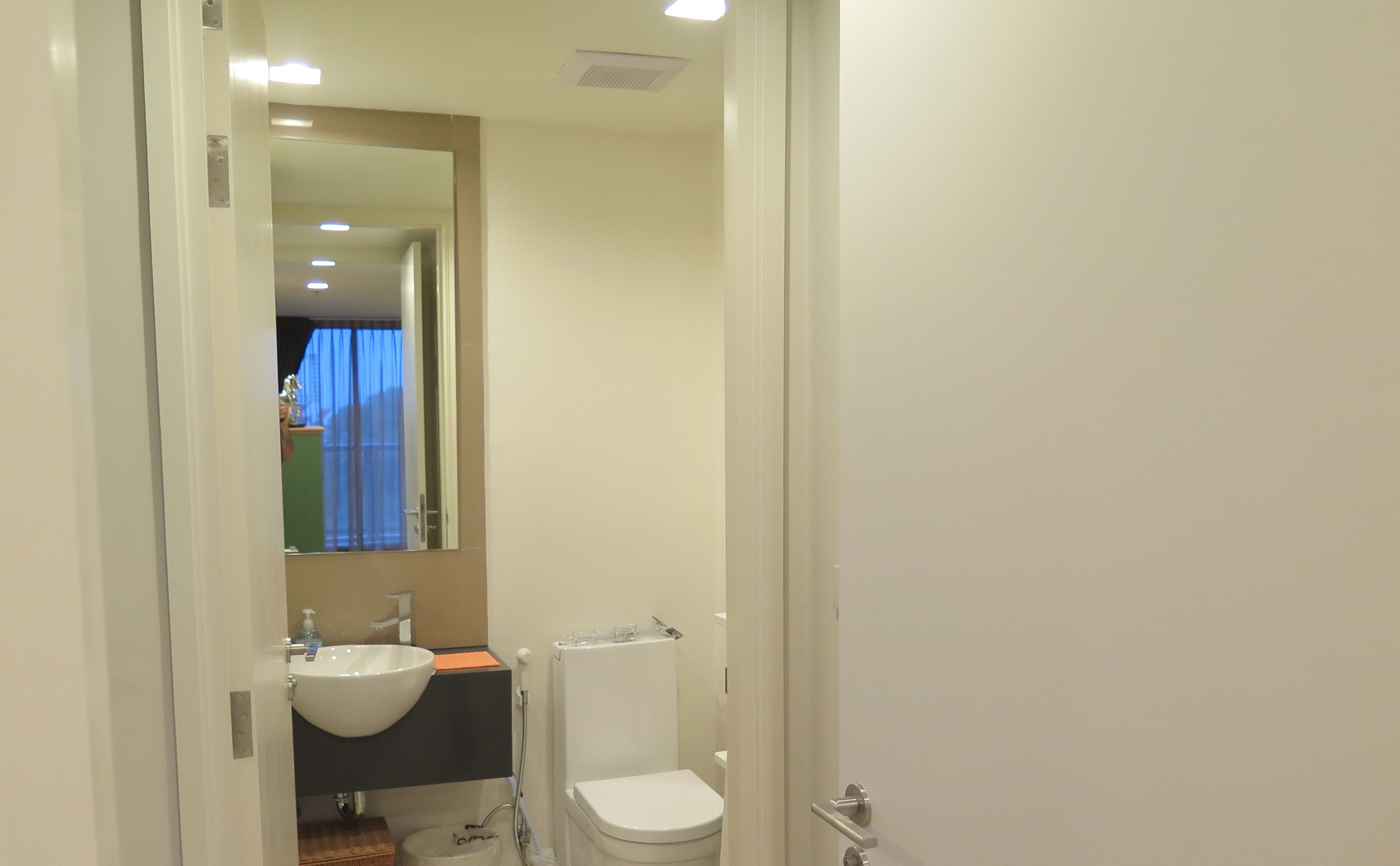 Un baño con un lavamanos blanco, un inodoro y un espejo.