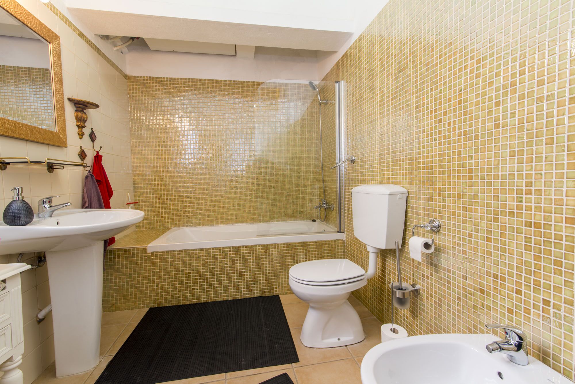 Un baño con bañera, inodoro y lavabo.
