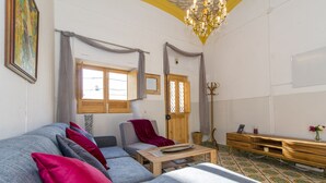 Une pièce comprenant un canapé gris, une table basse en bois et une table d’appoint en bois sur laquelle est posé un vase.