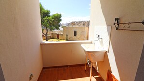 Une petite salle de bain avec un lavabo et une fenêtre donnant sur une cour.