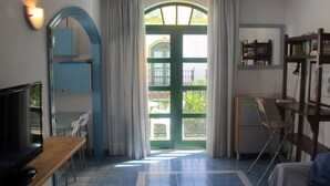 Een kamer met een groot raam, een bureau, een stoel en een bed.