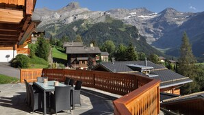 Un bâtiment en bois doté d’un balcon donnant sur un paysage montagneux.