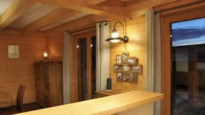 Un intérieur en bois avec un long comptoir, des armoires en bois et des tableaux encadrés accrochés au mur.
