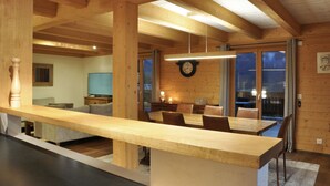 Un intérieur en bois comprenant une table à manger, des chaises, une horloge et un téléviseur.