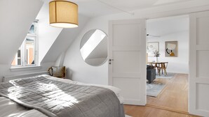 Un dormitorio con una cama grande, un espejo redondo y una lámpara en el techo.