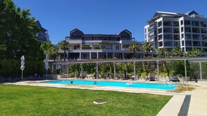 Ein modernes Hotel mit Schwimmbad, Außenbereich und üppiger Bepflanzung.