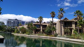 Un complexe hôtelier doté d’une piscine, de palmiers et de bâtiments modernes.