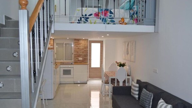 Eine moderne Wohnung mit Treppe, Essbereich und Wohnzimmer.