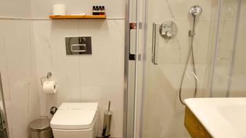 Un baño con inodoro, ducha y lavabo.