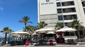 Un hôtel appelé « ERTAN OTEL » qui dispose d’une terrasse et de palmiers.