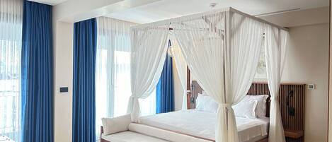 A bedroom with a four-poster canopy bed, a wooden bench, and a nightstand with a lamp.