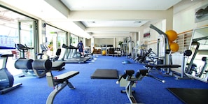 Una palestra con tapis roulant, macchinari per pesi e palle da ginnastica.