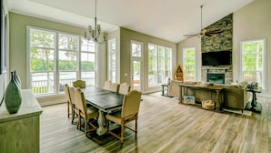 A spacious living room with a fireplace, dining area, and large windows.