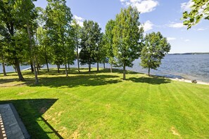 A grassy area with trees and a body of water. - Huge 8BR Lakefront Lake Anna, Beach, Dock, Hot Tub (Bumpass)