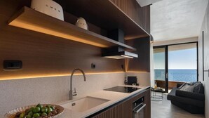 Uma cozinha moderna com uma ilha grande, eletrodomésticos embutidos e vista para o mar.
