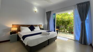A hotel room with a bed, a ceiling fan, a nightstand, and a view of the outdoors.