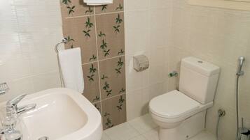 Un baño con lavamanos, inodoro y ducha.