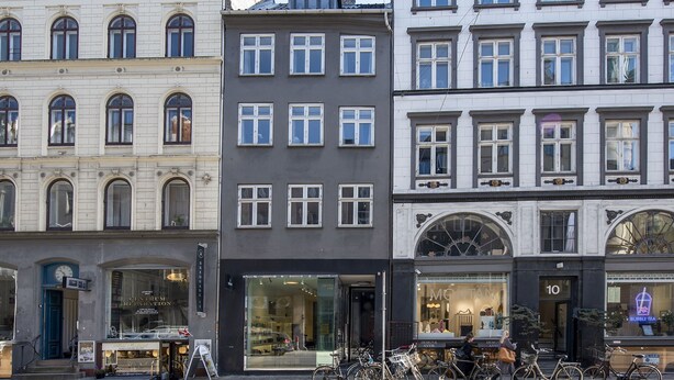 Une rangée de bâtiments avec des devantures de magasins, dont un magasin de bubble tea et un autre avec une grande vitrine.