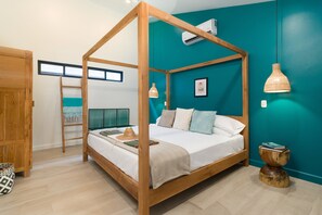 Un lit à baldaquin avec un cadre en bois, un mur d’accent de couleur turquoise et un ventilateur de plafond.