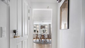 A hallway with a wooden floor leading to a dining area with a round table and chairs. - Regent 4- Cute 1-Bdr Apt in Centre of Copenhagen (København)