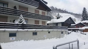 A building with multiple balconies and a snow-covered roof.