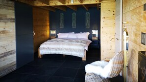 Une chambre à coucher avec un lit, une chaise et une table de chevet.
