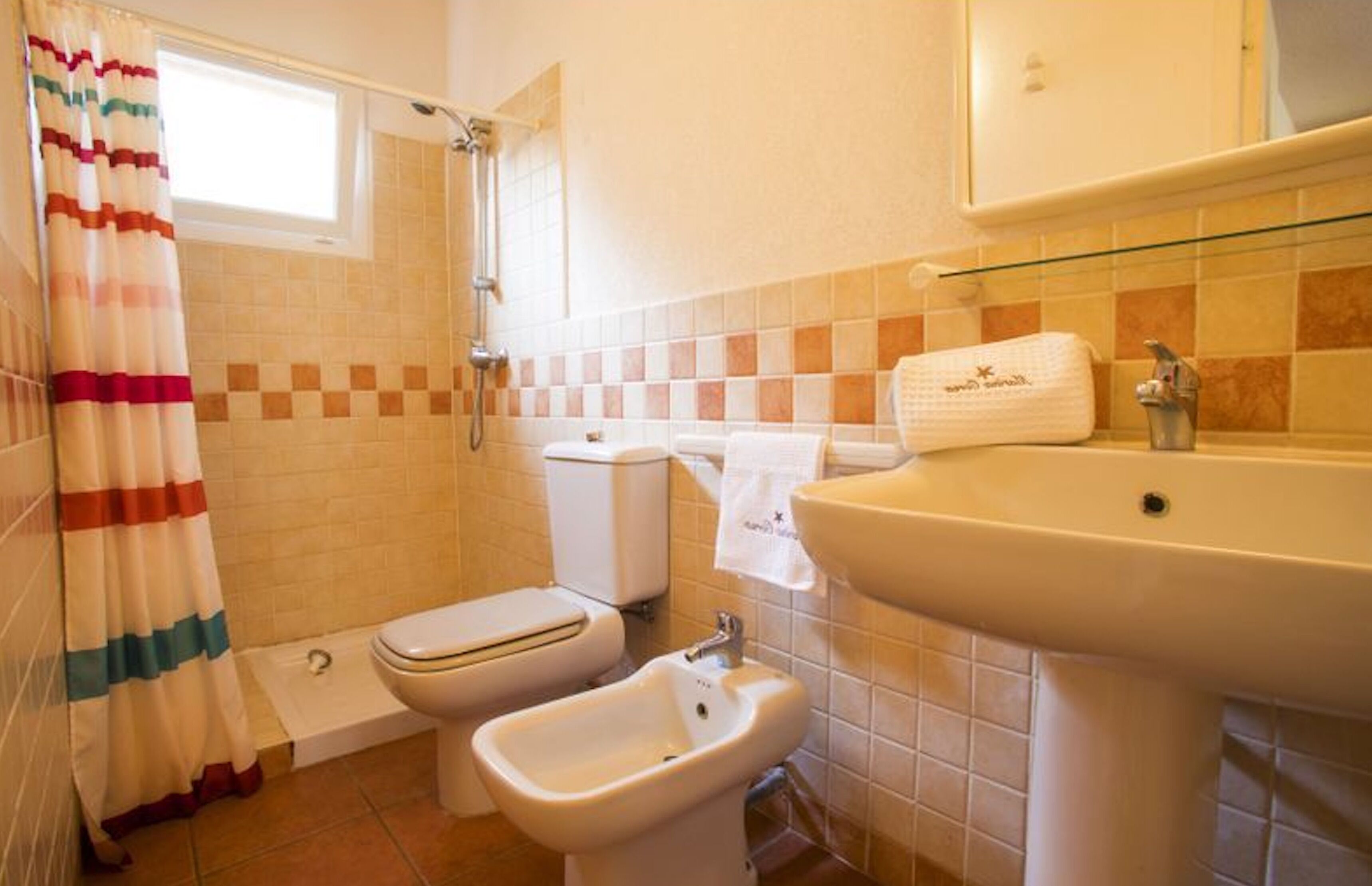 Un baño con ducha, inodoro, bidé y lavamanos.