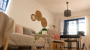 Een woonkamer met een bank, een salontafel, een eettafel en een stoel.