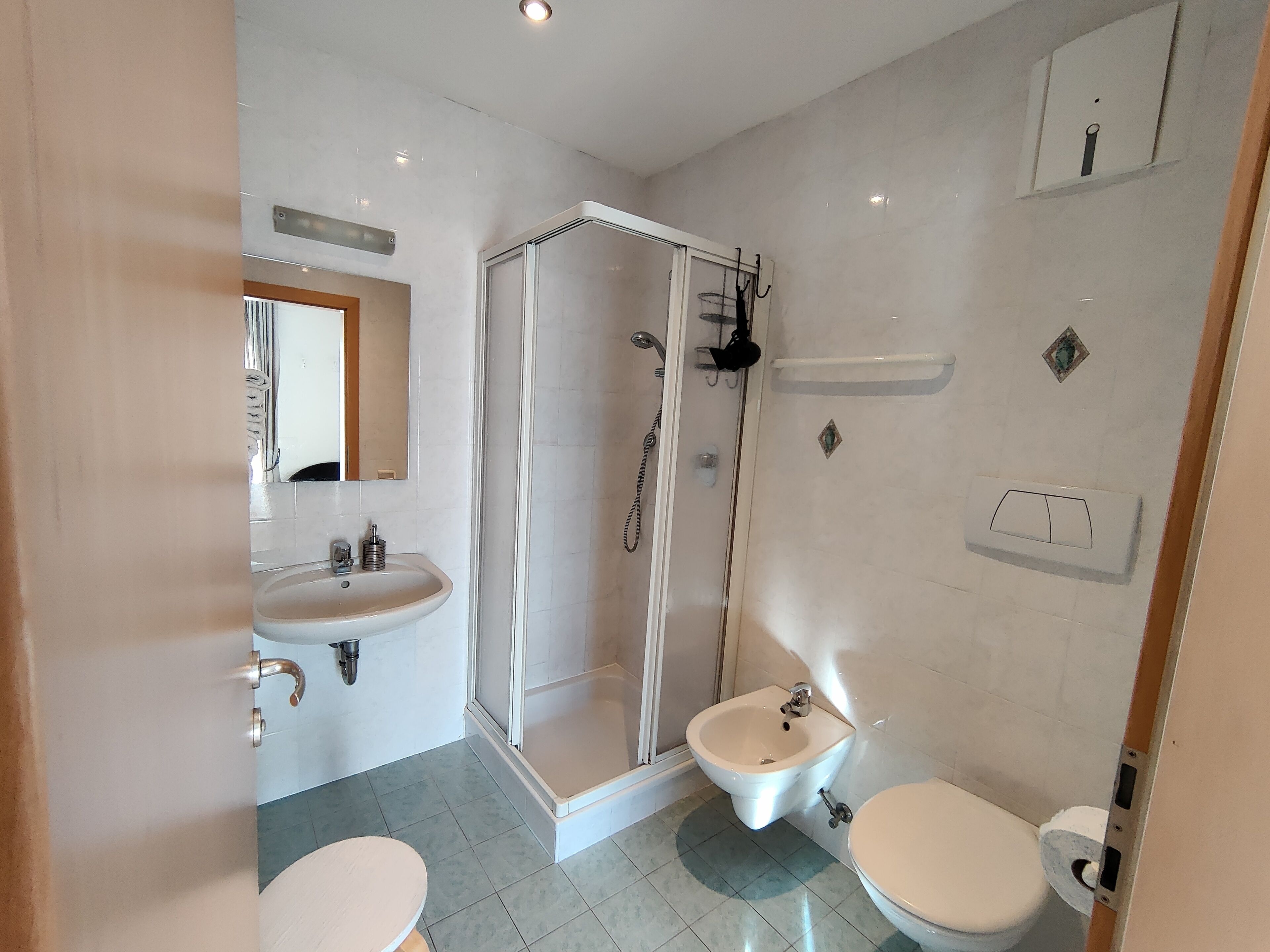 Ein modernes Badezimmer mit einer Duschkabine, einem Waschbecken und einer Toilette.