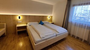 Ein Schlafzimmer mit einem hölzernen Bett, zwei Nachttischen und einem Beistelltisch.