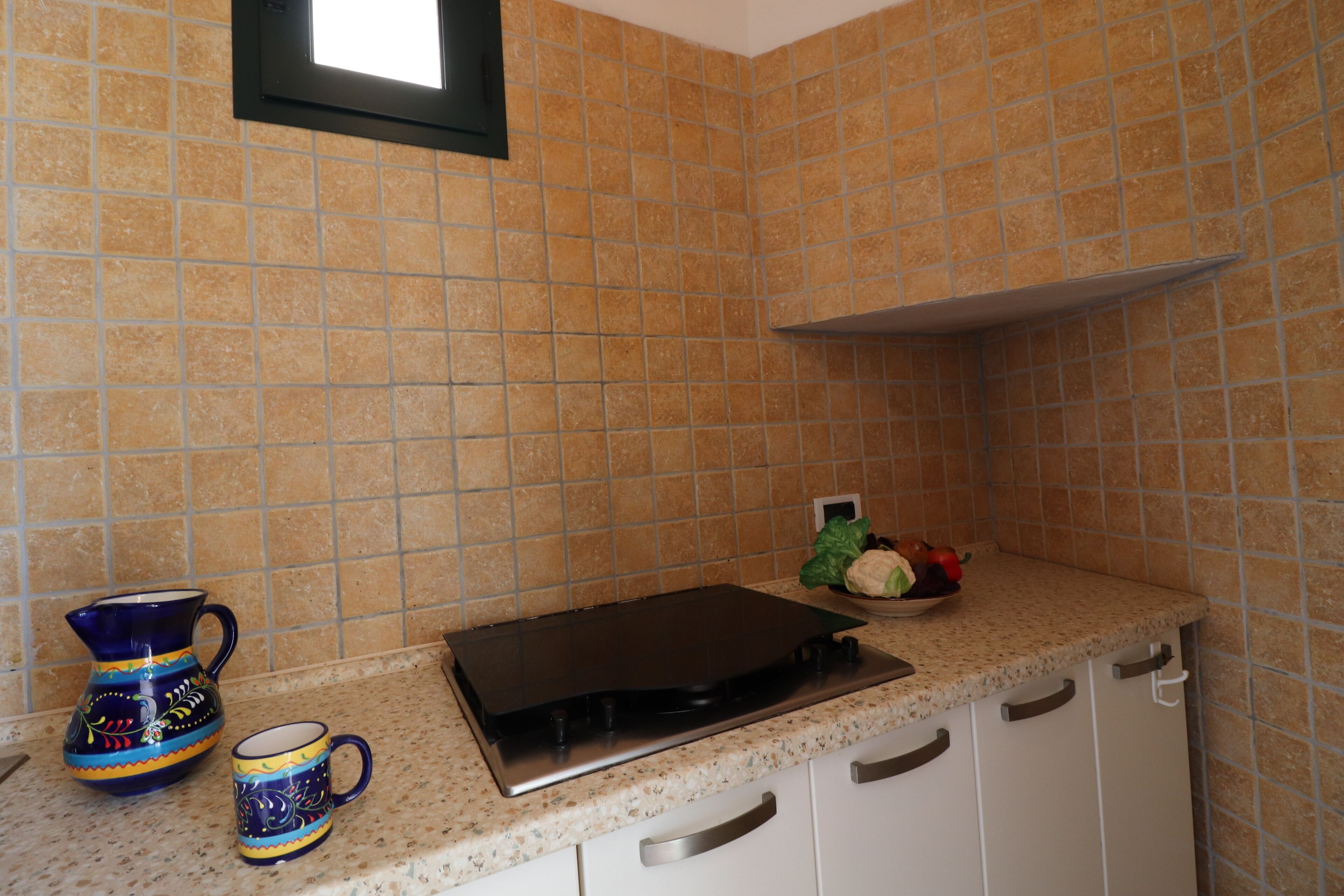 A kitchen with a stove, a sink, and a countertop.