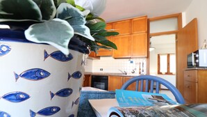 Una cocina con armarios de madera, un microondas y una planta en maceta sobre la encimera.