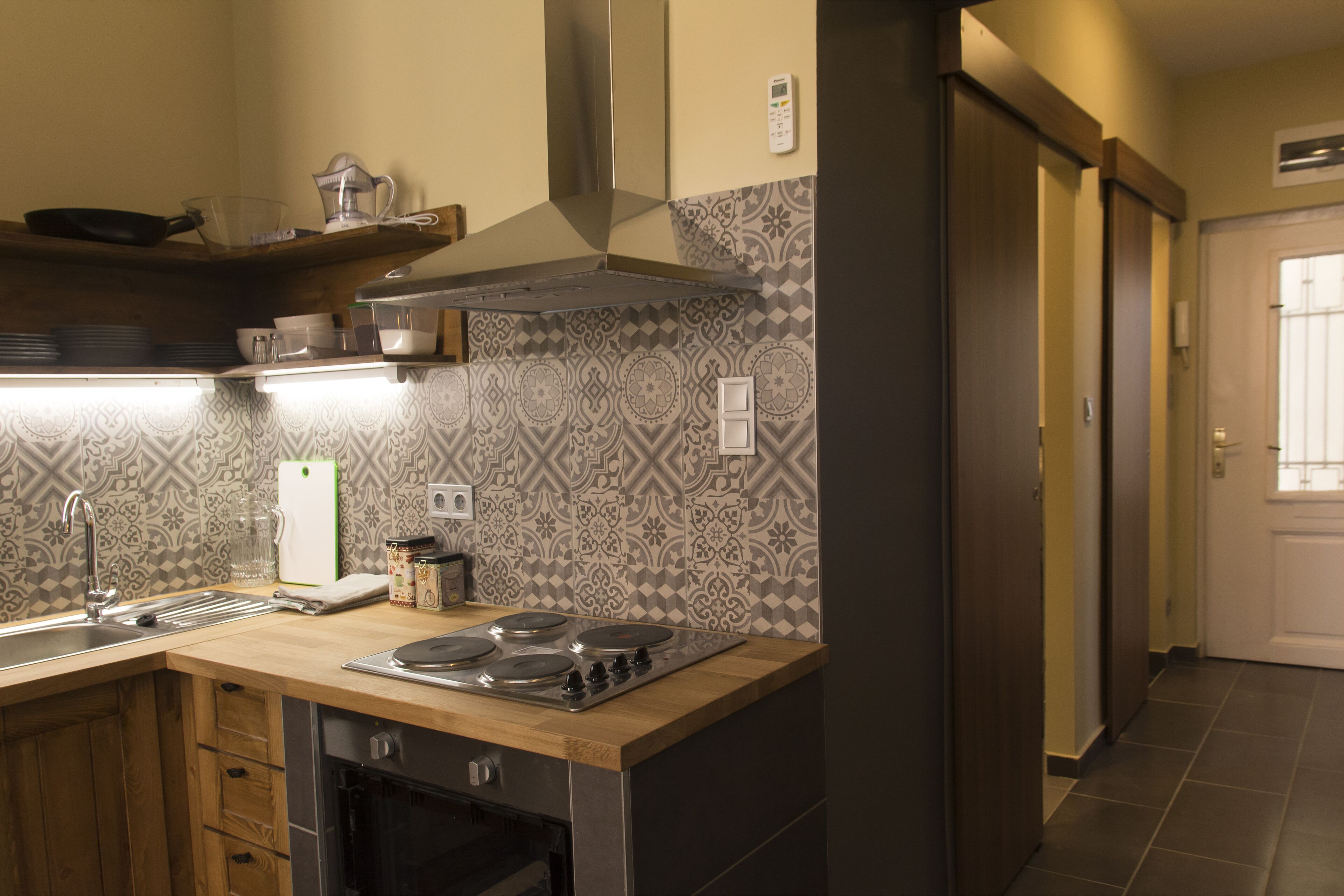 A kitchen with a stove, sink, and various kitchen items.