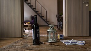 Una mesa de madera con una botella de vino, una copa, un puro, un farol y un cubo de Rubik.